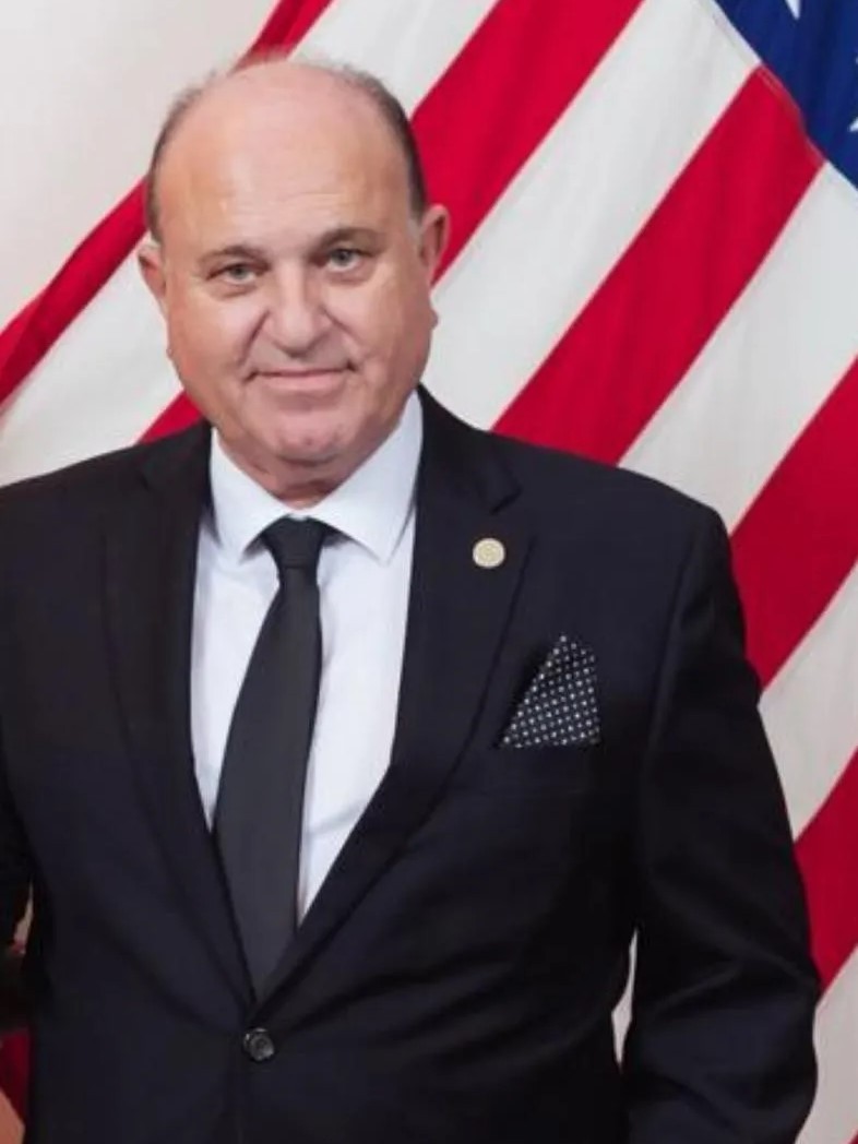 Yoram Naor, Honorary Consul General and VP of the Ambassador Clubs of Israel, with the United States flag